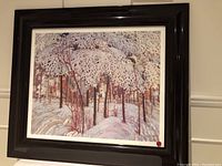 Frontal view of the framed print showing snowy forest landscape with white snow and reddish tree trunks.