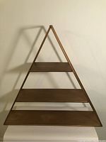 Front view of the metal triangle frame shelf with three wooden shelves, showing full triangular shape and shelf layout.
