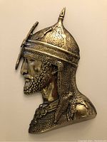 Front view of the metal warrior profile showing detailed facial features and helmet.