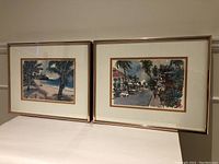 Photo showing both framed watercolours side by side on a flat surface.