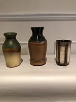 Front view of all three vintage West German pottery vases lined up, showing size differences and glazing.