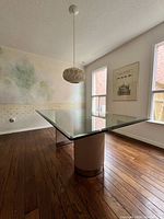 Dining table angled shot showing textured half-drum base and beveled glass top