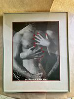 Frontal photo of "Passion and Art" print, showing male nude torso with red nails on hands and chrome frame with double mat.