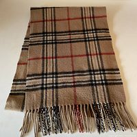 Full folded view of the wool and cashmere blend checkered scarf showing fringe detail.