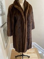 Front full view of vintage mink coat on mannequin showing cinnamon and brown fur colors with 3/4 length sleeves.