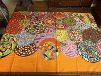 Large square scarf laid flat showing the circular colorful abstract MOD design on orange background