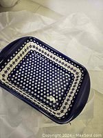 Photo of the rectangular ceramic dish showing the blue and white hand-painted dot and floral design.