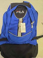 Front view of new blue FILA backpack with attached tag showing the condition and brand.