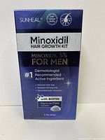 Front of Sunheal Minoxidil 5% Hair Growth Kit box showing branding, key features such as reducing hair loss, restoring thinning hair, and stimulating hair regrowth with biotin.