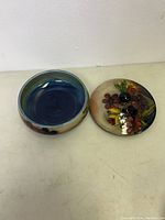 Open lidded jar showing the blue interior and floral exterior design on jar and lid.