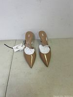 Top-down view of nude patent leather pointed toe heels with Zara brand visible, showing tags attached and tissue paper inside shoes.