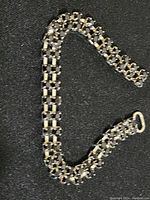Full view of 10-inch dress necklace with black rhinestones in silver-tone setting laid against a dark fabric background