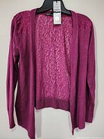 Full front view of the pink long-sleeve open-front women's top revealing sheer fabric details and solid sleeve knit