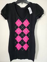 Front view of black short-sleeve top with deep V-neck and pink argyle pattern