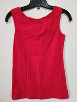 Front view of the new red sleeveless top hanging on a black hanger against a white background.