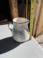 Side view of hand-painted ceramic water pitcher with abstract designs and handle showing size measurement of about 6 inches.