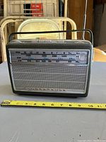 Front view of the Normende radio showing tuning scale and speaker grille with measuring tape for size reference.