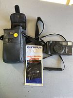 Camera, carry case, and instruction booklet displayed together on a flat surface.