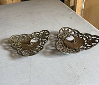 Pair of vintage brass pricket candle holders side by side showing top with pricket spikes and intricate openwork design.