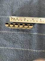 Top-down photo showing length scale with tape measure, displaying the device measuring approximately 10 cm, and clear labeling of notes on round tubes from A to G.