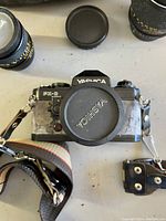 Close top-down view of Yashica FX-D Quartz camera body with lens cap on attached lens and camera strap clips visible.
