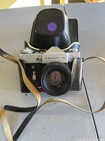 Front view of Zenit-B camera with attached lens and shoulder strap, showing overall condition and lens glass.