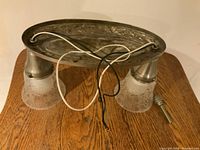 Top view of antique Victorian Revival light fixture base showing metal oval base and wiring for electrical.