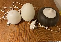 Three diffusers in small, medium and large sizes, with visible plugs on wooden surface