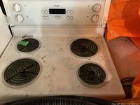 Photo of Inqlis electric stove showing four coil burners and digital display control panel with dust and dirt.