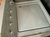 Top view of control panel and lid showing water level, temperature, and cycle control knobs