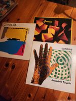 Shows three vinyl album covers by Genesis: Abacab, an album with geometric shapes, and Invisible Touch