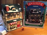 Front and side view of the porcelain florist shop miniature and its original Dickensville Collectables box with branding and item image.