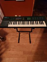 Full view of Yamaha PSR-6 electronic keyboard on adjustable stand, showing keyboard layout and integrated speakers.