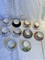 Top view of the 10 tea cups paired with saucers showing various floral designs and some gold detailing