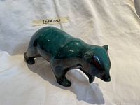 Front side view of Blue Mountain Pottery bear figurine showing glossy green and blue glaze finish and detailed form.