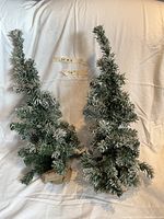 Photo showing both tabletop Christmas trees with snowy frosted branches and natural wood bases, approximately 26 inches tall.