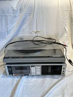 Front angled view of the Kenwood stereo system with visible turntable under dust cover and connected cables