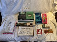 Overview of vintage nurse's uniform and accessories all in original packaging laid out on white fabric background.