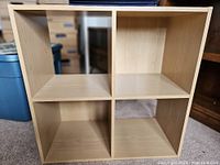 Light wood 4-cube storage unit showing empty compartments and wood grain texture.