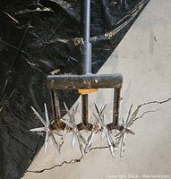 Close-up of the star-shaped metal tines for cultivating and aerating soil.