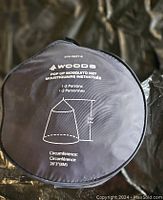 Top view of the round black carrying case with product details and diagram of net dimensions and capacity for 1-2 persons