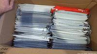 Box containing stacks of folded eBay branded bubble mailers, showing quantity and organization.