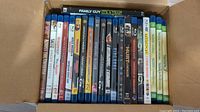 Box with 21 various Blu-ray movies packed, titles include Family Guy: It's a Trap!, Across the Universe, Saul Uncut Edition, Heroes Season 3, Rome Complete Series, and others.