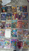 Overview of 25 assorted comic books spread out on floor, showing various titles and colorful covers, Marvel themed mostly.