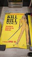Photo of the full Kill Bill Vol. 2 movie theater poster laid on a floor, showing the full image of the Bride and the poster text
