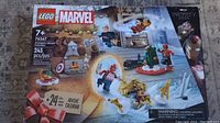Front of sealed LEGO Marvel Avengers Advent Calendar box showing 243 pieces and 24 compartments for builds, featuring Marvel characters and holiday theme.
