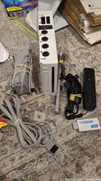 Photo of the Nintendo Wii console and included cables, accessories, and controller.