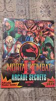 Front cover of Mortal Kombat II Arcade Secrets guide book showing colorful character artwork and official logo.