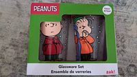 Front of box showing two of the Peanuts character glasses visible in the packaging.