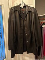 Front view of black leather jacket on hanger